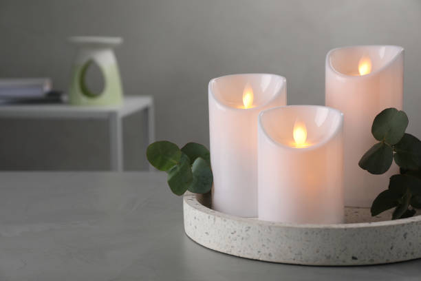 istock Decorative LED candles and eucalyptus on grey table, space for text 1326223560