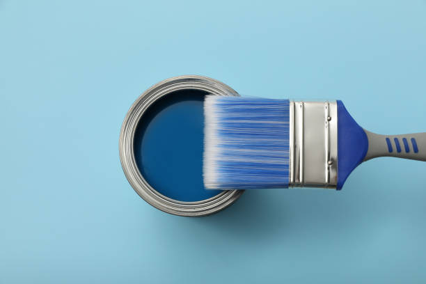 istock Can of paint and brush on light blue background, top view 1326223612