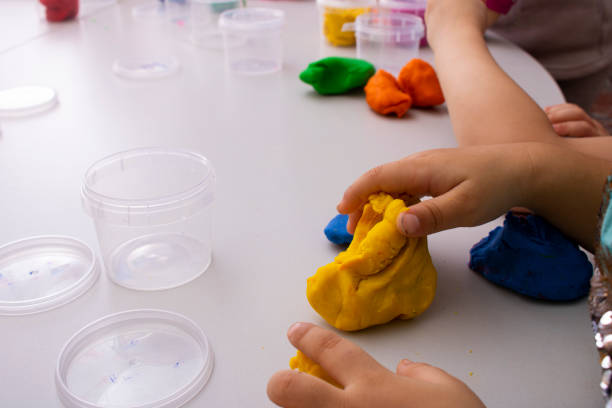 istock Child concentrated with play dough building, kids hands 1326225634