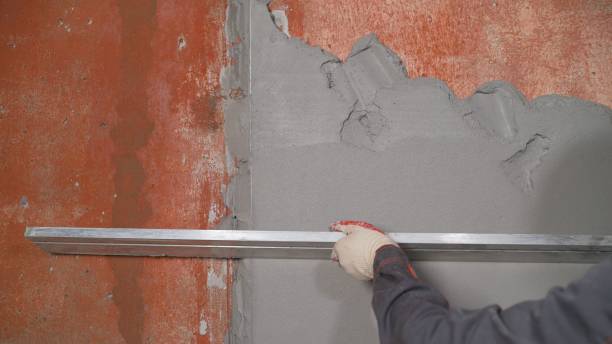 istock Plasterer at work on construction site, leveling walls and checking quality. Industrial worker on construction site. Worker leveling walls from mortar 1326226338