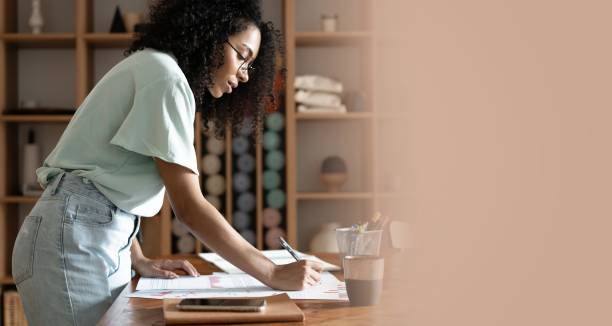 istock Mixed-race beautiful businesswoman working with papers while standing in modern office 1326227107
