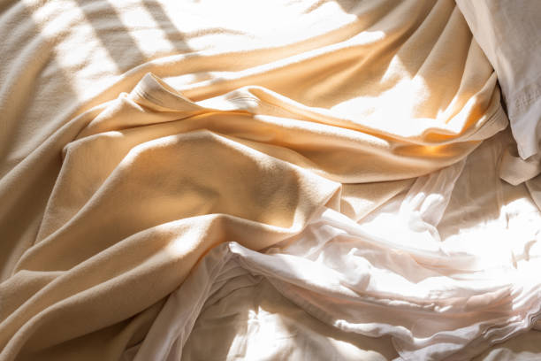 아침 햇살에 지저분한 침대 시트와 담요를 닫습니다 - textile folded white nobody 뉴스 사진 이미지