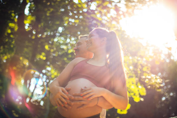 Sports couple standing in the park and touch the stomach.