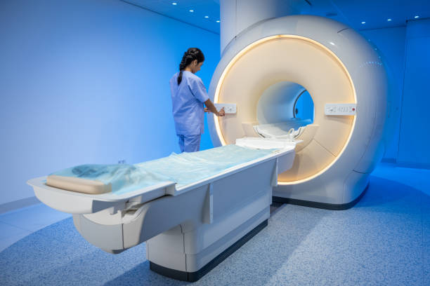 istock Female technologist standing next to the MRI scanner 1326232297