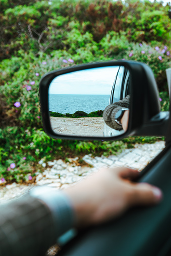 sea reflection in car rear mirror. road trip. summer vacation
