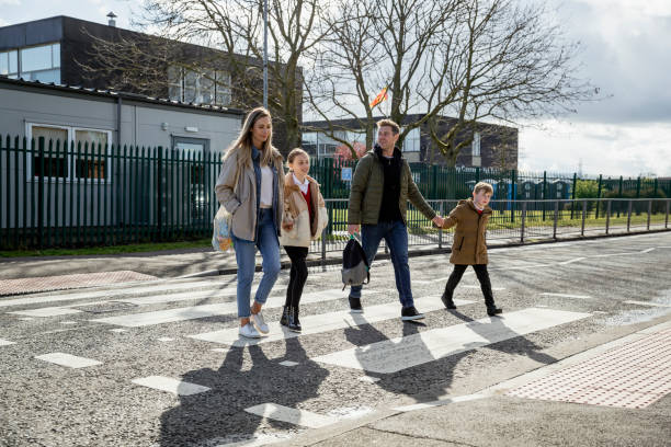 familia caminando a lo largo del paso de cebra - crossing zebra crossing crosswalk street fotografías e imágenes de stock