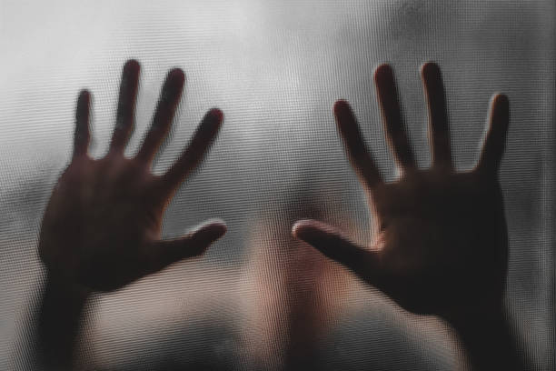 istock Shadow of blurry hand behind frosted glass 1326236026