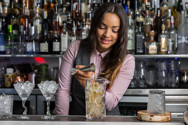 istock Positive female barkeeper making cocktail in bar 1326237987