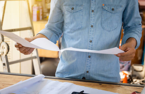 istock Architect working on blueprints, Engineer working on paper document in factory, Young man planning work in room 1326238122