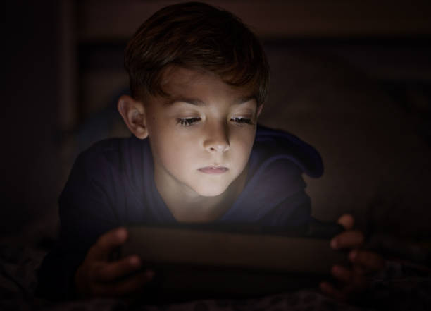 istock Shot of adorable little boy using a digital tablet at night 1326240006