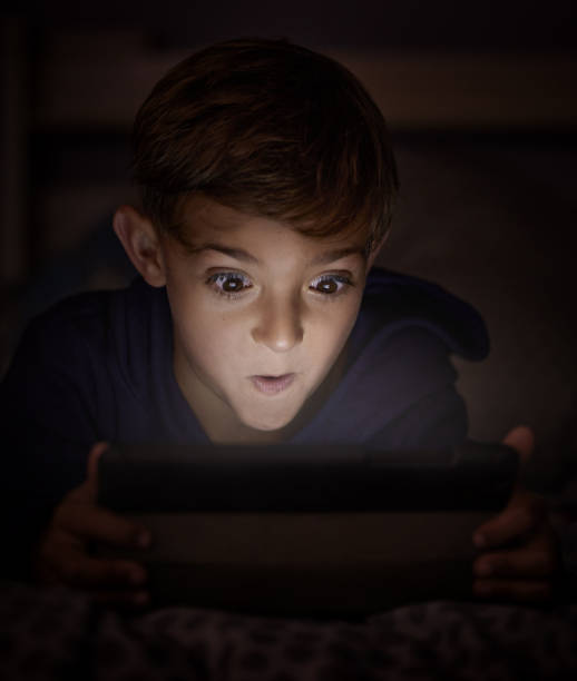 istock Shot of adorable little boy using a digital tablet at night 1326240012