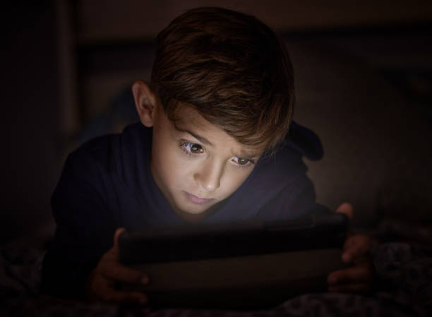 istock Shot of adorable little boy using a digital tablet at night 1326240013