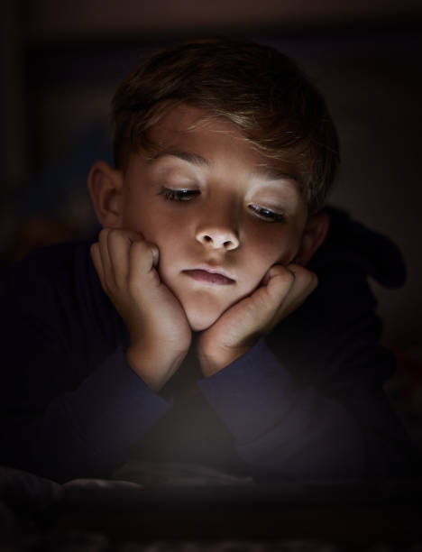 istock Shot of adorable little boy using a digital tablet at night 1326240016