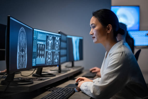 radiologa femminile che analizza l'immagine della risonanza teste - radiologist computer doctor mri scan foto e immagini stock