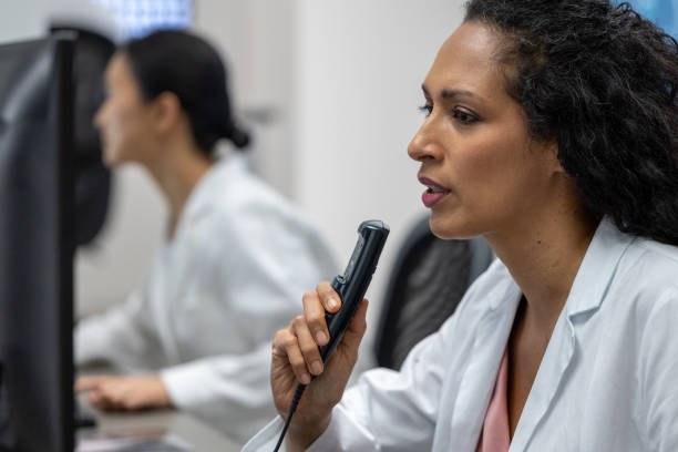 istock Female radiologist speaking into a dictation recorder while looking at MRI scan 1326241059