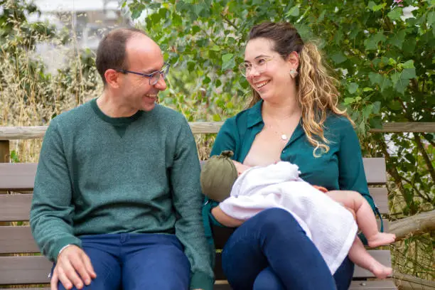 Mother and baby in a public park, while mum breastfeeds her baby