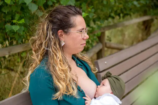 Mother and baby in a public park, while mum breastfeeds her baby