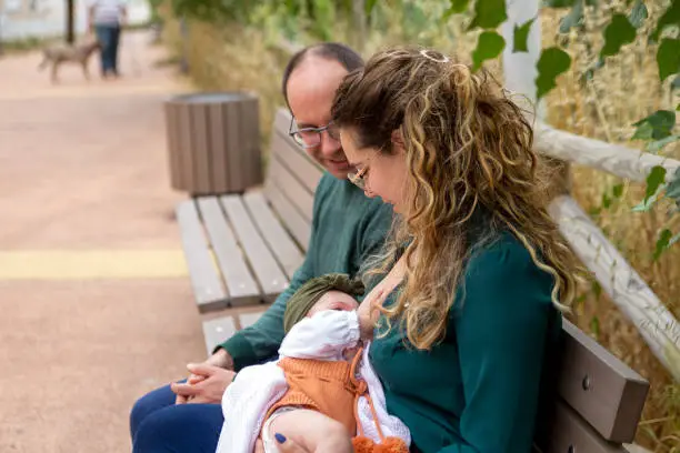 Mother and baby in a public park, while mum breastfeeds her baby