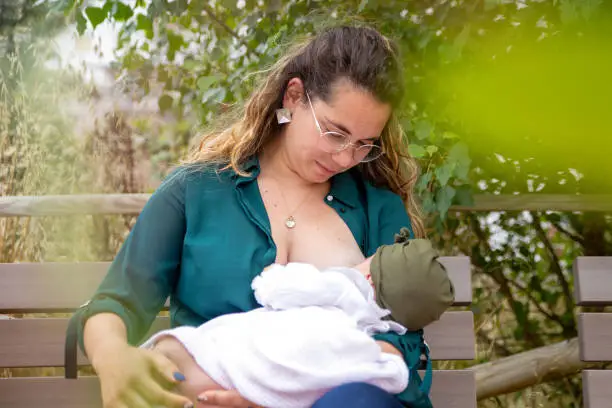 Mother and baby in a public park, while mum breastfeeds her baby