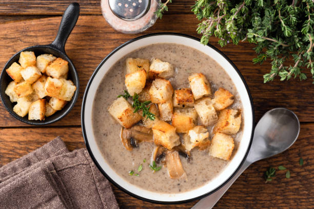 sopa de crema de setas con croutons en un tazón - sopa de crema fotografías e imágenes de stock