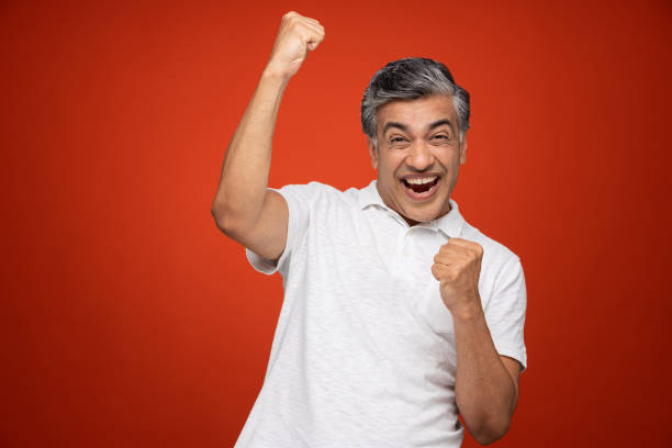 retrato del hombre maduro de pie aislado sobre el fondo rojo:- foto de archivo - cheering men t shirt celebration fotografías e imágenes de stock