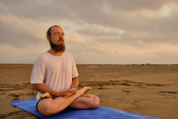 istock Portrait of man meditating at beach 1326249742