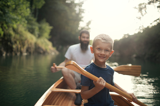 Two Males Embarking On A Canoe Fun Adventure In River