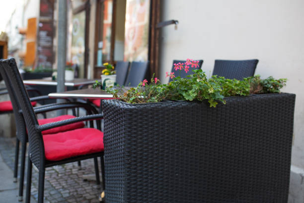 istock Empty wicker chairs and tables with flowers outside a street cafe 1326251701