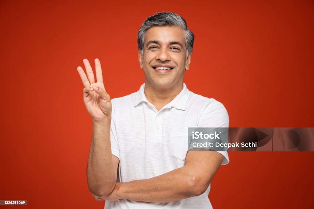 Portrait of mature man standing isolated over red background:- stock photo India, 40-49 Years, Adult, Adults Only, mature men Number 3 Stock Photo