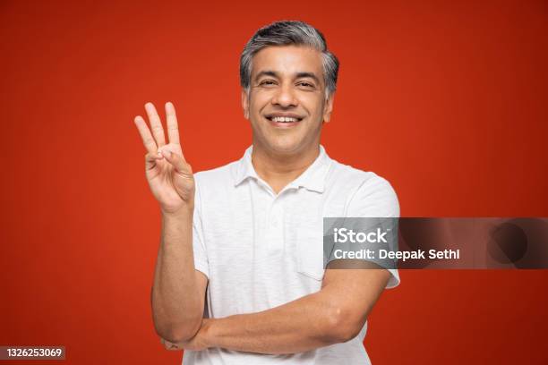 Portrait Of Mature Man Standing Isolated Over Red Background Stock Photo Stock Photo - Download Image Now