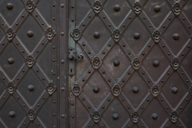 istock Old rusty metal door with a knob and keyhole. Empty space 1326253228