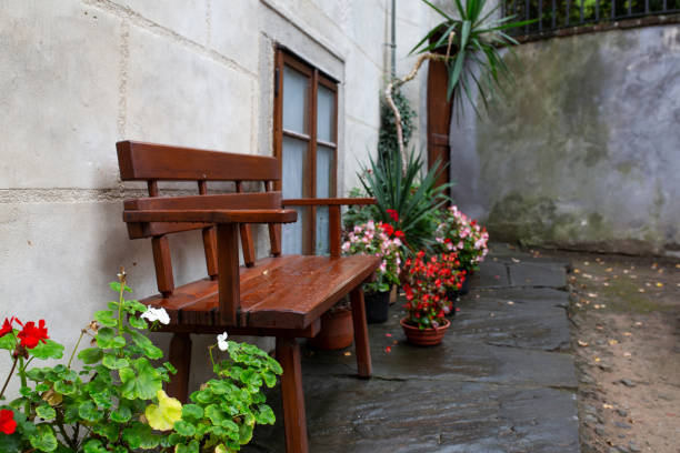 istock Wooden bench with flower beds after the rain 1326253345