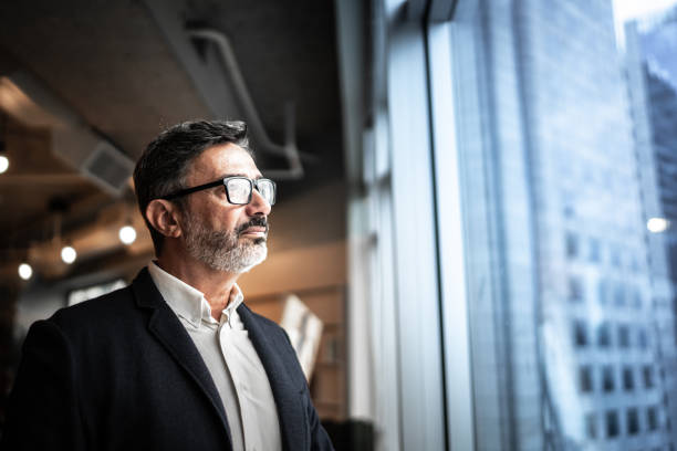 Middle-aged man looking far on a building window