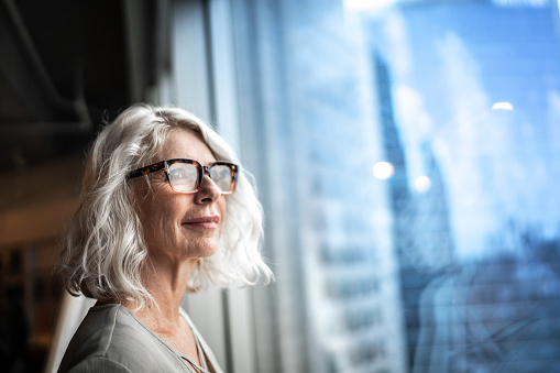 Mature businesswoman looking out of window.
