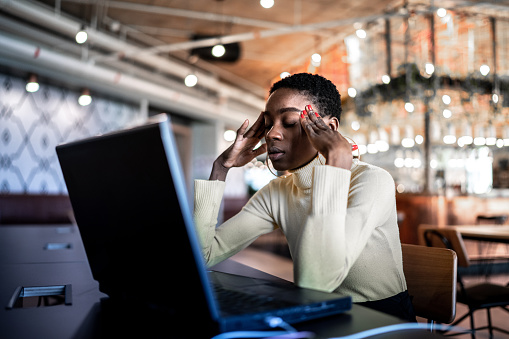 Young businesswoman working with headache