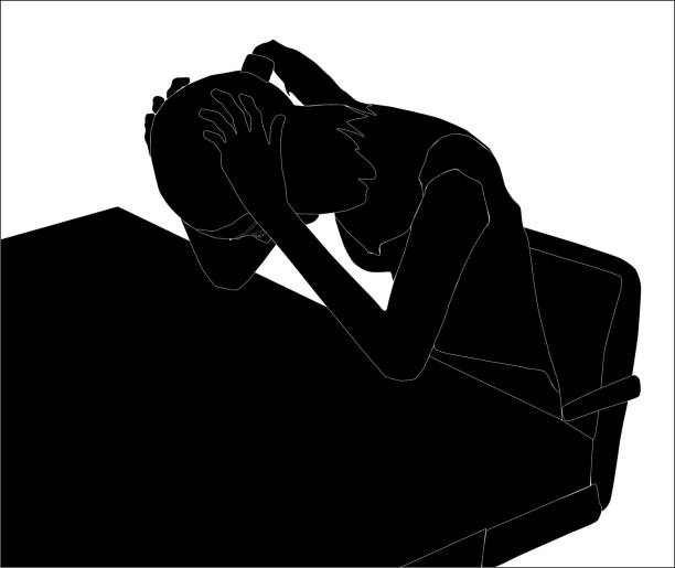 istock Silhouette of a woman holding her head on the desk 1326256016
