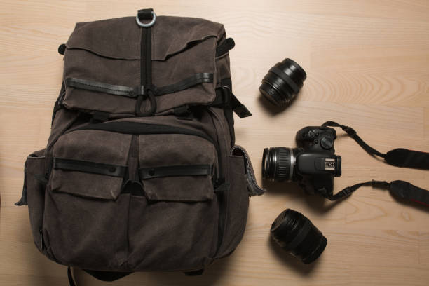 istock Photographer's backpack with digital photo camera and replaceable lenses 1326257071