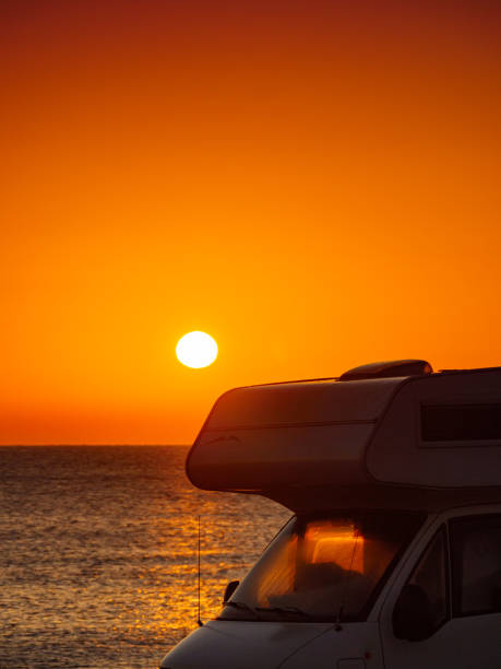istock Camper car on beach at sunrise 1326259790