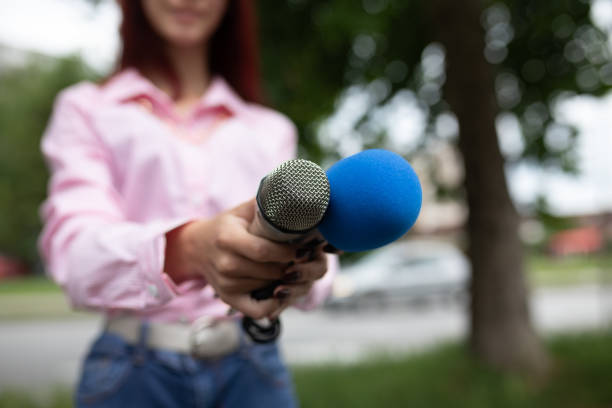 istock What is your storry? Journalist at news conference, writing notes, holding microphones 1326261983