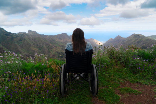 mujer discapacitada discapacitada en silla de ruedas en la colina de la montaña disfrutando de la vista - cuadriplégico fotografías e imágenes de stock