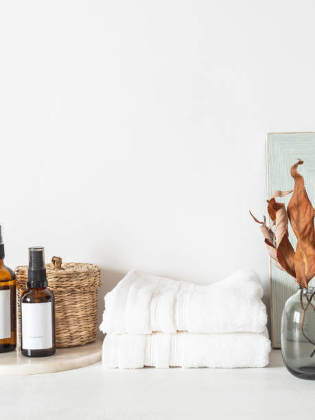 istock White bath background front view with glass vase, cosmetics, white towels and decor on white shelf 1326272917