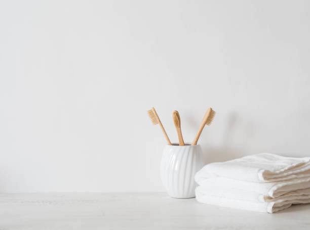 istock Minimal bath background with bamboo toothbrushs in ceramic glass and swhite towels 1326273029