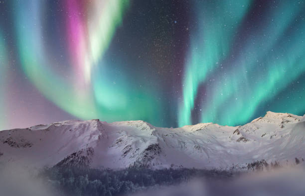 aurores boréales au-dessus d’une chaîne de montagnes enneigée, paysage fantastique avec de la neige et un ciel étoilé avec des aurores boréales - lake night winter sky photos et images de collection