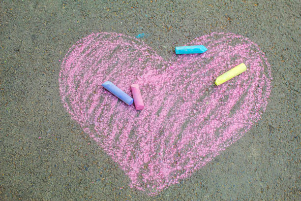 istock child painted a heart on the asphalt with chalk. selective focus 1326278863