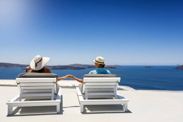 istock A romantic tourist couple sits holding hands on white sunbeds 1326279242