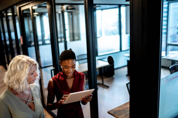 istock Business partners walking using digital tablet in corridor 1326279257