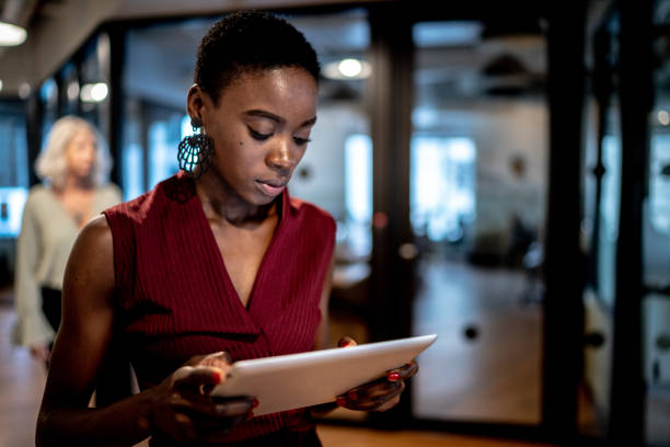 オフィスの廊下でデジタルタブレットを使用して若いビジネスウーマン - digital tablet businesswoman young women watching ストックフォトと画像