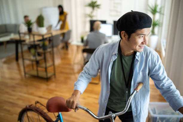 istock Japanese businessman pushing bicycle and leaving workplace after work 1326279865