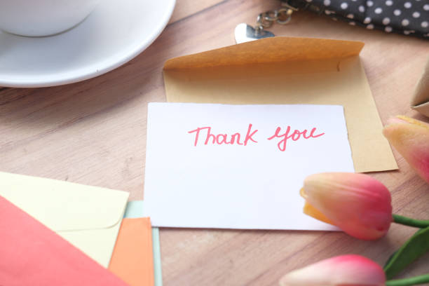 istock thank you message, flower and envelope on wooden table 1326285830