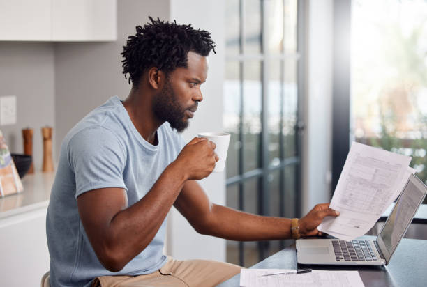 istock Shot of a man going through some paperwork and looking worried at home while having coffee 1326287562